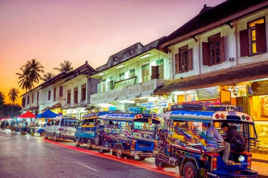 Luang Prabang night market with colorful tuk tuks and shops – Auasia Travel